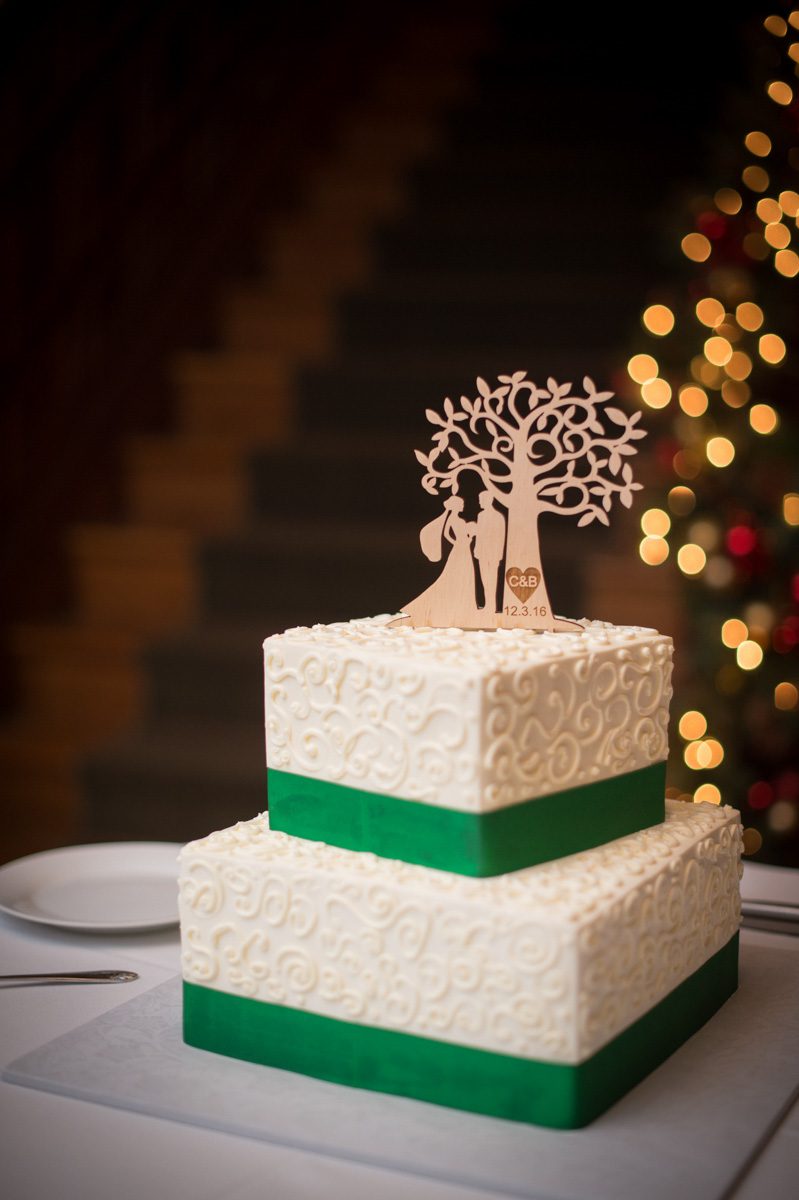 A December Wedding two tier white cake with bride, groom, tree silouette topper